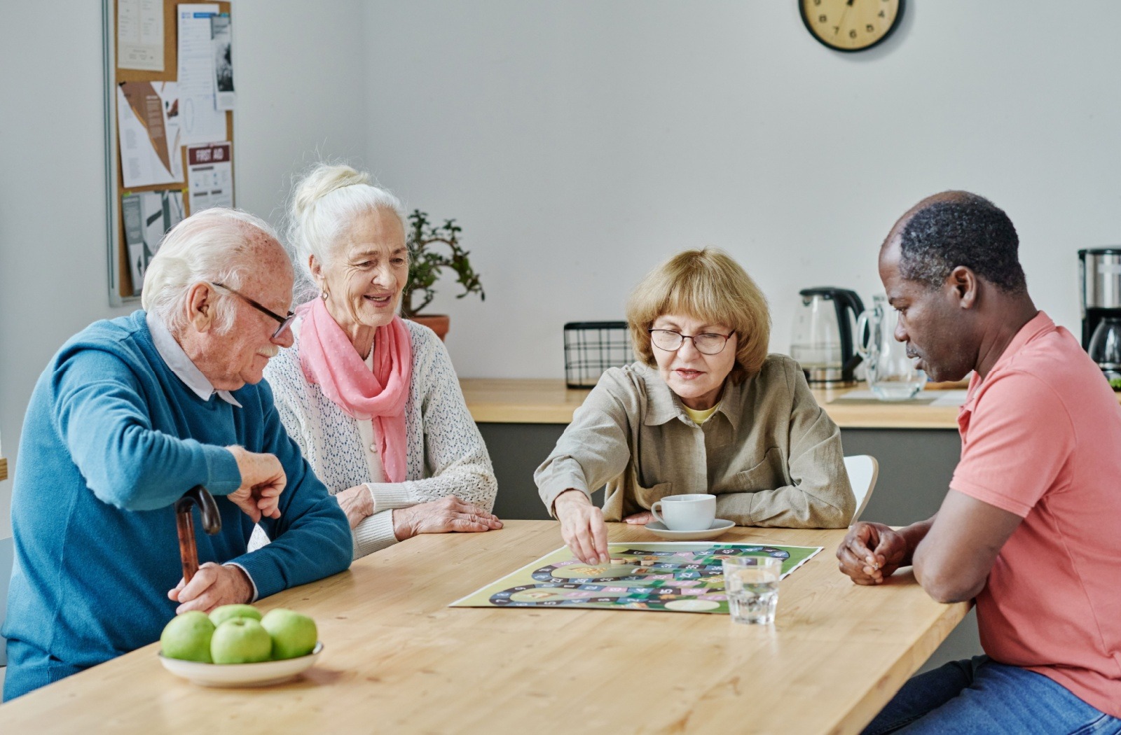 A group of senior friends play a tabletop board game.
